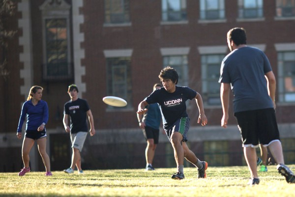 UConn students playing frisbee outdoors